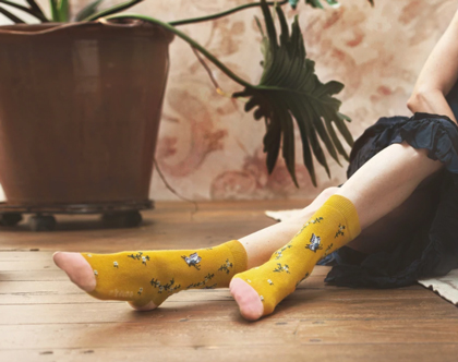 Woman with style, wearing interesting socks, sitting on floor.