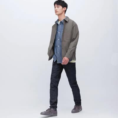 Uniqlo jeans on a man wearing a green jacket